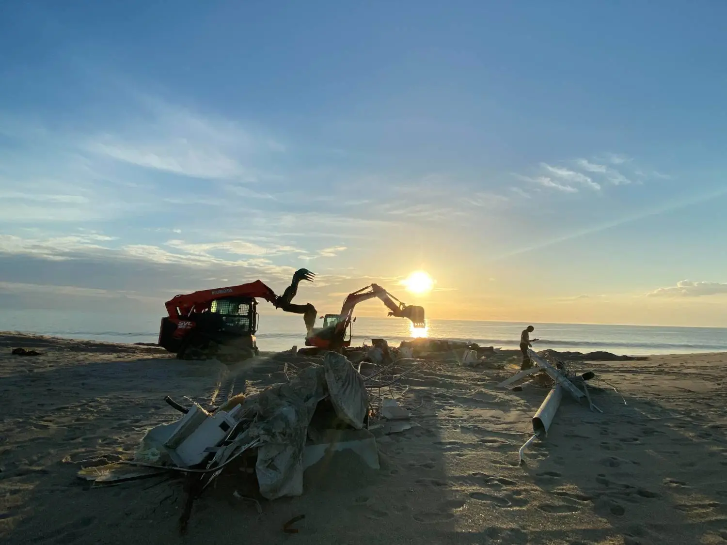 Sandy beach and a dune being shaped by an excavator