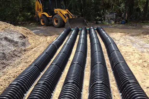 Rows of black drainfield pipe laid in a trench